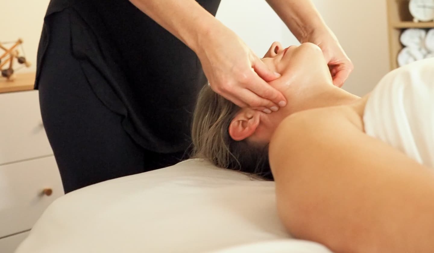 Liandi Richards performing gentle lymphatic and fascial release work on a client's neck